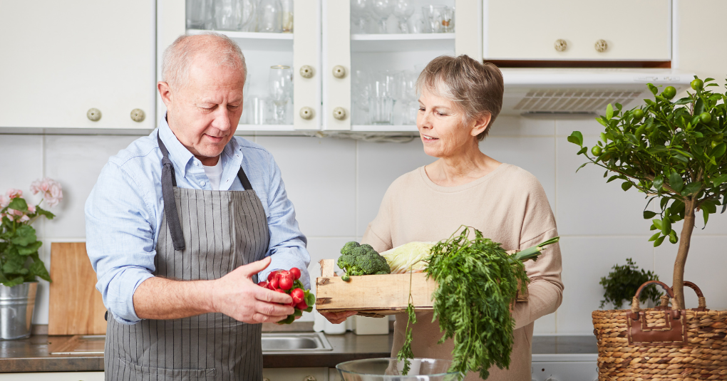 Couple looking through boxed vegetables in kitchen.